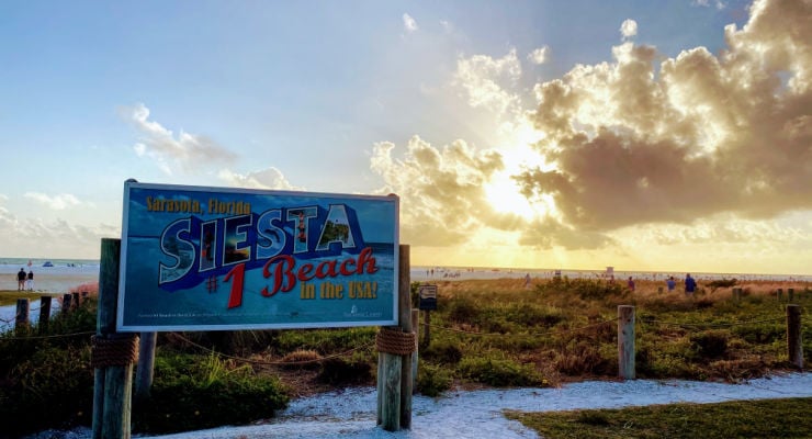 Sunset at a beach with a sign "Siesta Beach Florida #1"