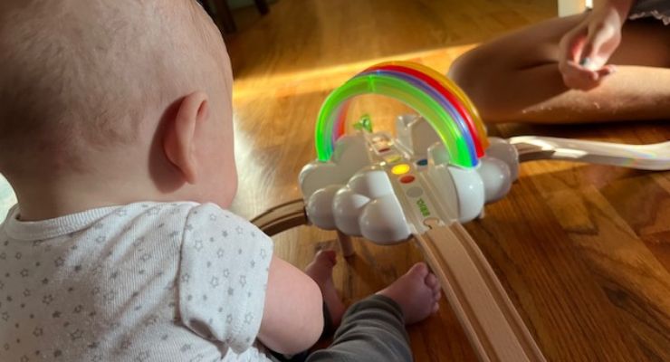 Baby with rainbow train set