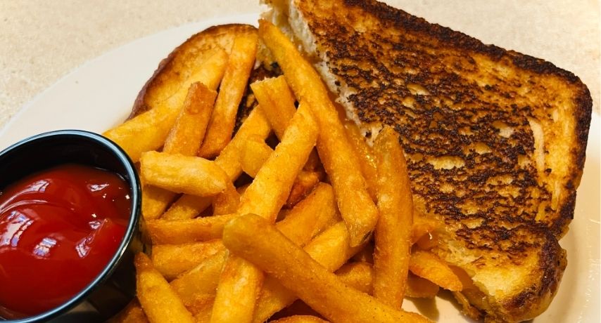 Grilled cheese sandwich, french fries, and ketchup