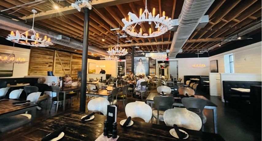 Open dining room with tables, booths, and rustic decor
