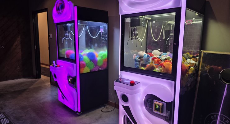 Two claw machines filled with colorful prizes in the arcade room at Hobo's restaurant in Rock Hill SC